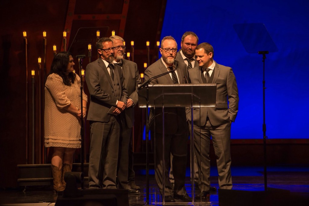 Members of Balsam Range (Buddy Melton, Marc Pruett, Tim Surrett, Darren Nicholson, Caleb Smith) accept one of several awards in Raleigh during the IBMA Awards. Also pictures is artist Amanda Smith, award presenter. Photo credit: Todd Powers. 